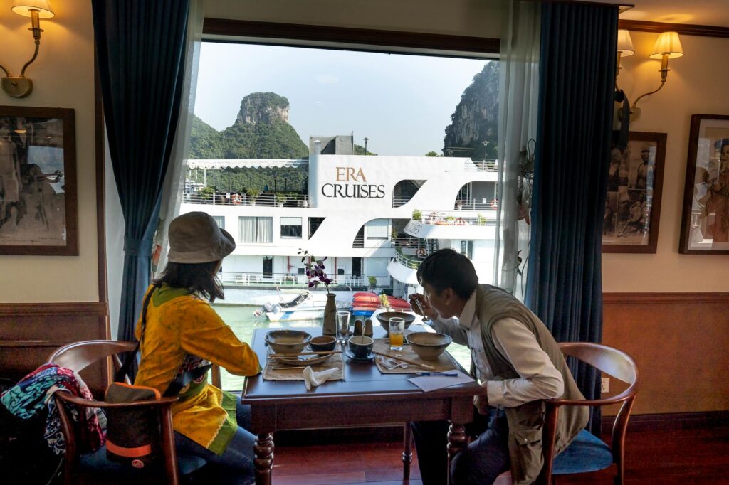 asian traveler with anonymous girlfriend having lunch on yacht